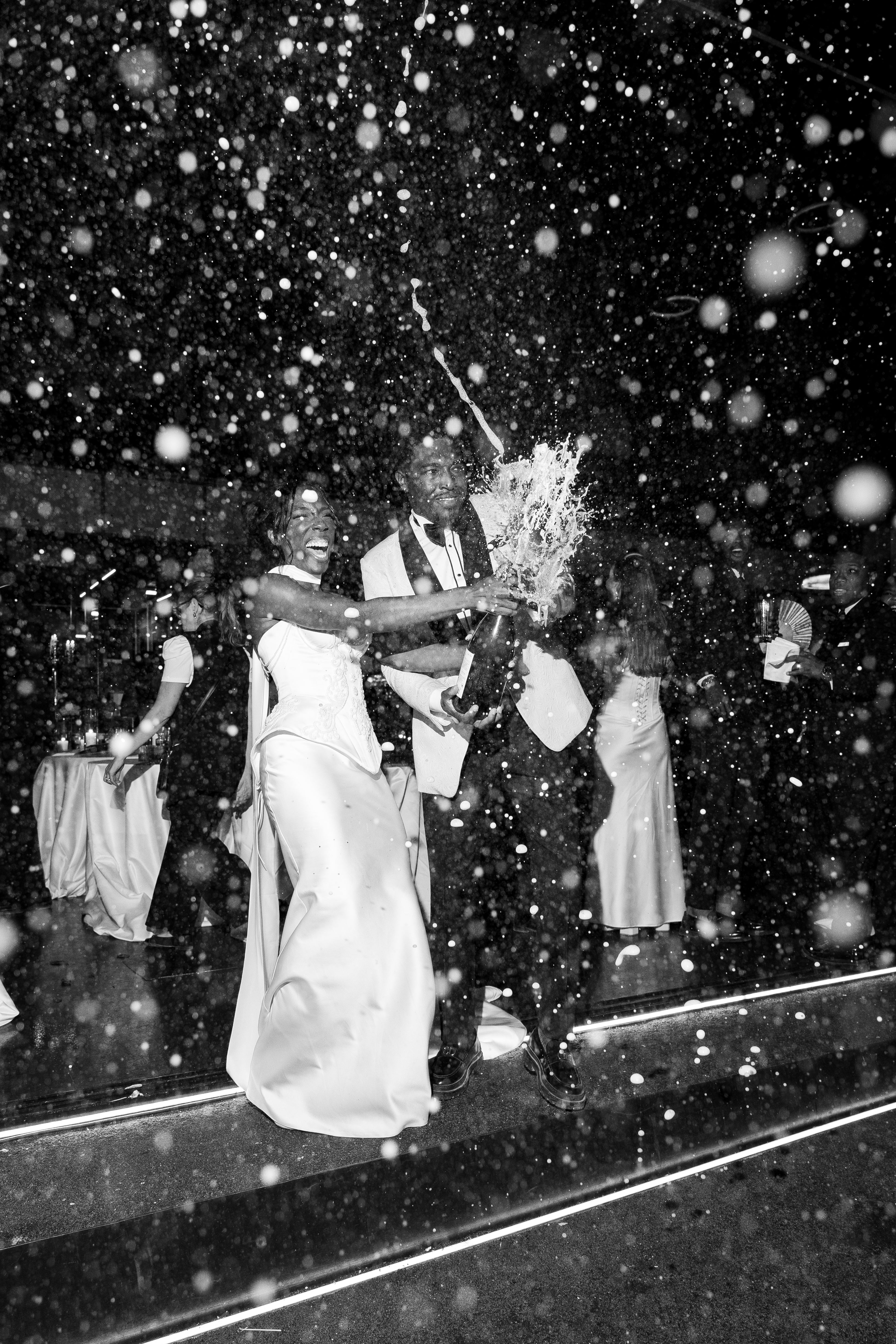 Black and white photo of a couple on a stage with snow falling