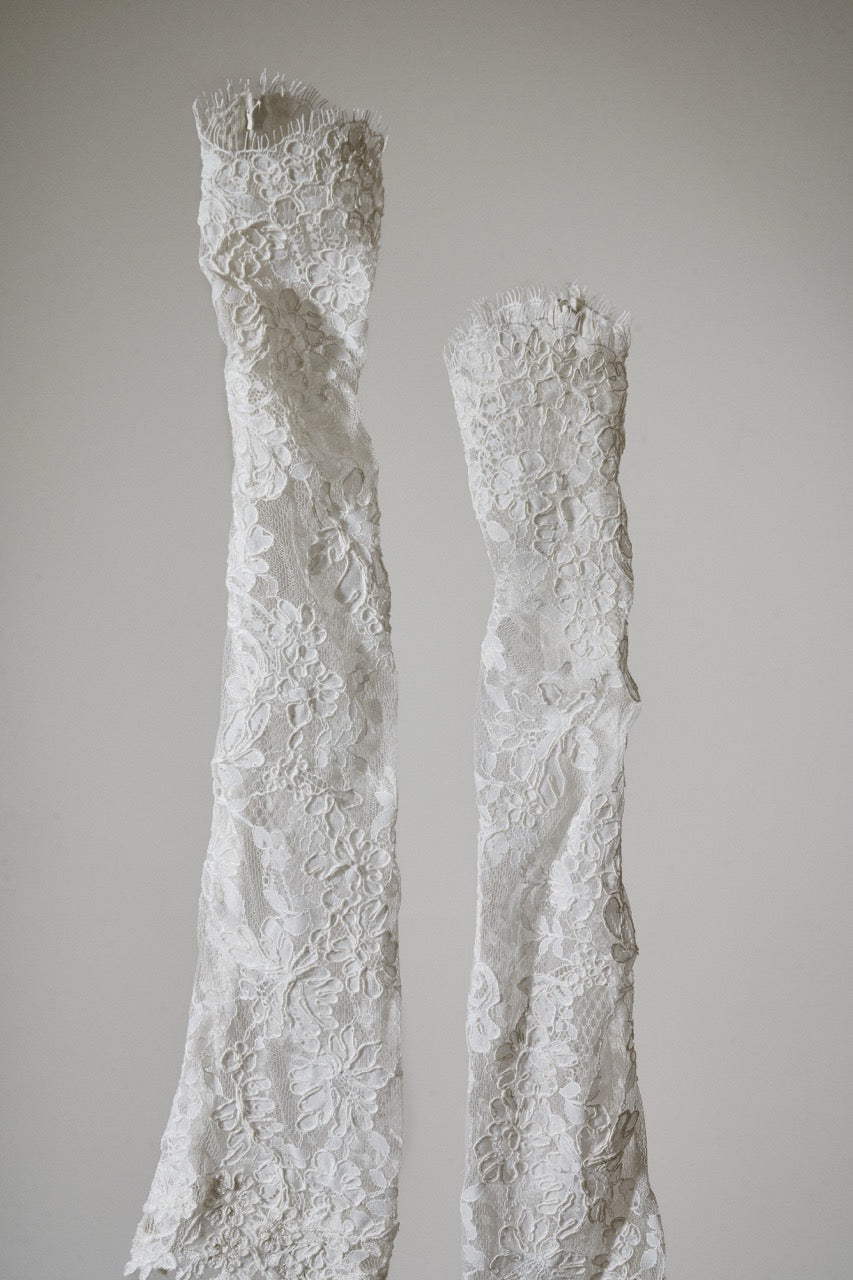 Two textured white ceramic legs against a plain background
