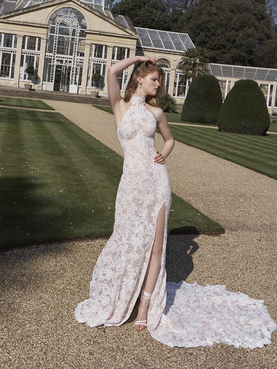 Woman in a white lace wedding dress standing in a garden setting