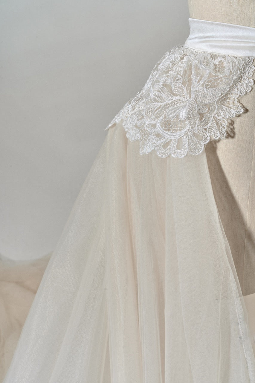 Beige skirt with lace trim on a plain background