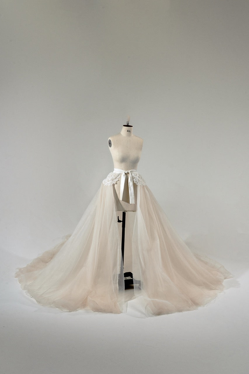 Mannequin wearing a beige tulle skirt against a plain background
