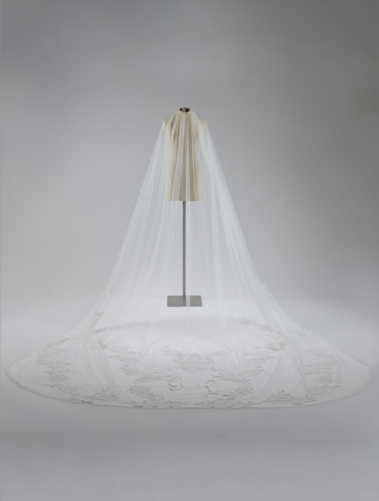 White wedding veil on a mannequin against a gray background