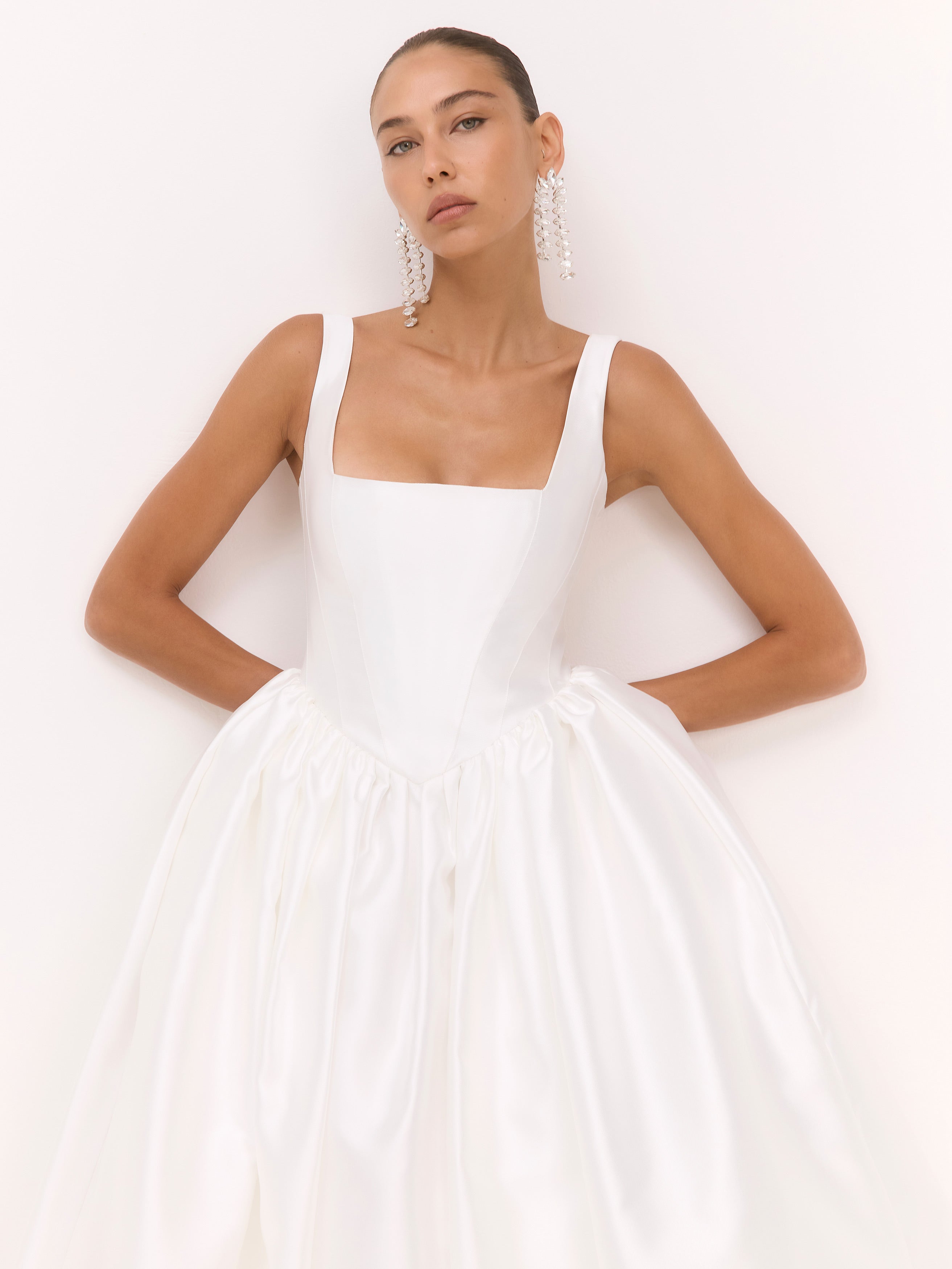 Woman wearing a white dress against a white background